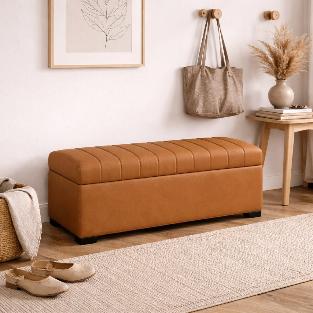 Brown leather ottoman in a room with a rug, shoes, and wall art.