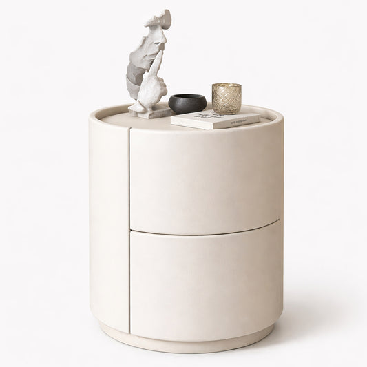 Beige cylindrical side table with decorative items on a white background