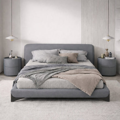 Modern bedroom with a gray bed and matching nightstands.