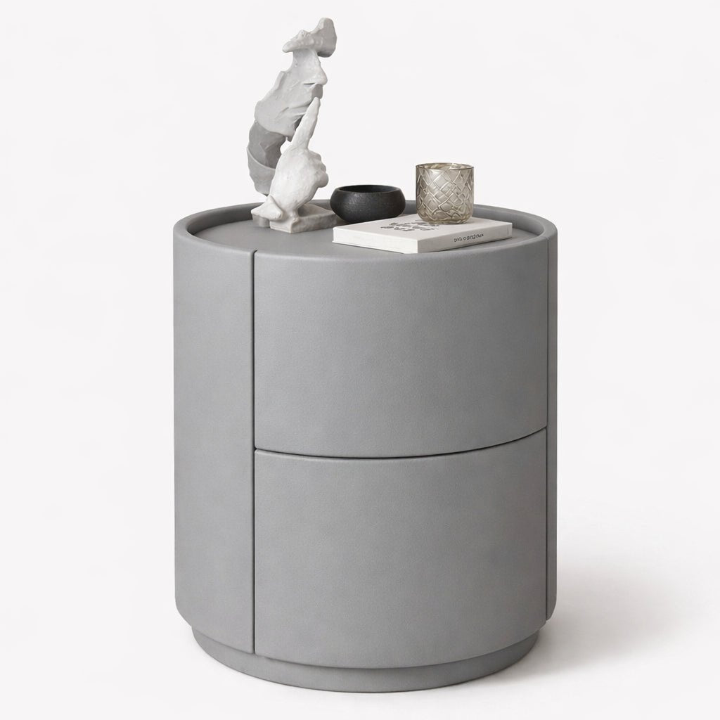 Gray cylindrical side table with decorative items on a white background