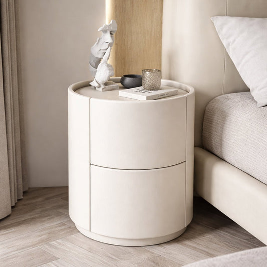 Round nightstand with a drawer next to a bed in a bedroom setting