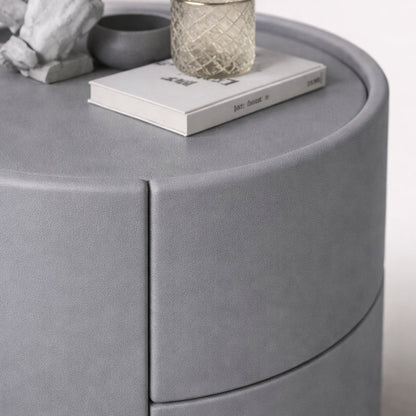 Round gray table with a book and decorative items on top