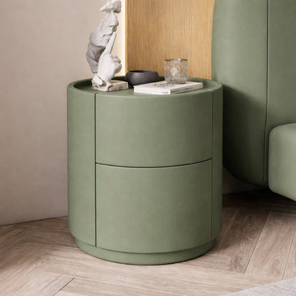 Green cylindrical side table with decorative items in a room setting