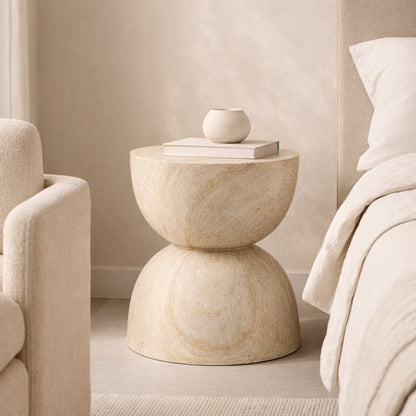 Beige side table with a small vase and book in a neutral-colored room.