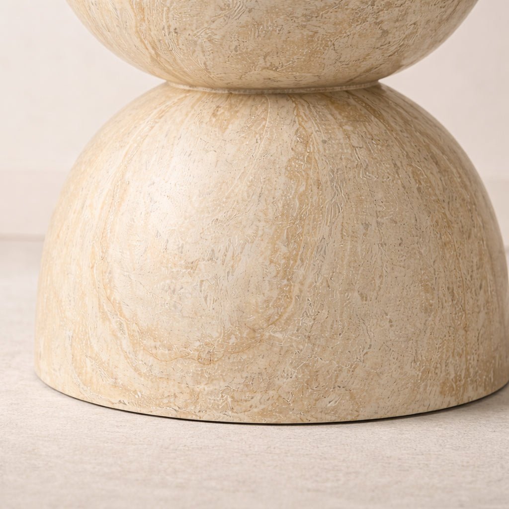 Beige stone table with two stacked cylindrical forms on a light background