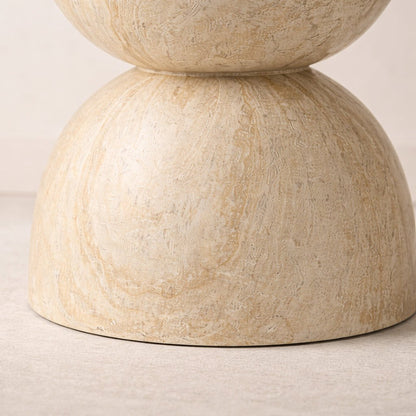 Beige stone table with two stacked cylindrical forms on a light background