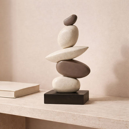 Stack of balanced stones on a table with a neutral background
