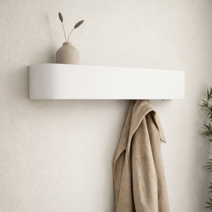 White wall-mounted shelf with a beige vase and dried plants against a light beige wall.
