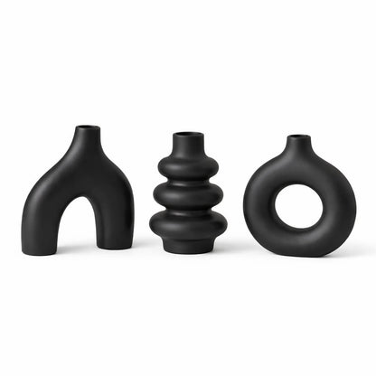 Three black ceramic vases of unique designs on a white background