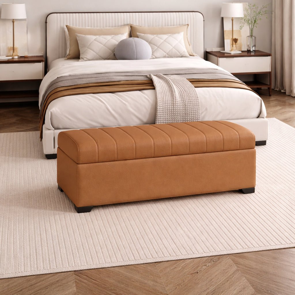 Brown ottoman in front of a neatly made bed in a bedroom setting.