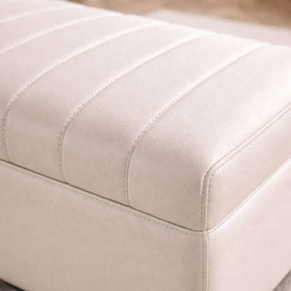 Close-up of a beige ottoman with visible stitching details.