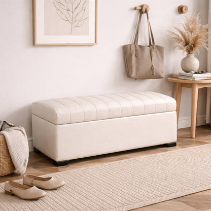 White storage bench in a room with a rug, shoes, and wall art.