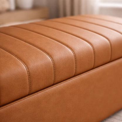 Close-up of a brown leather ottoman with a blurred background